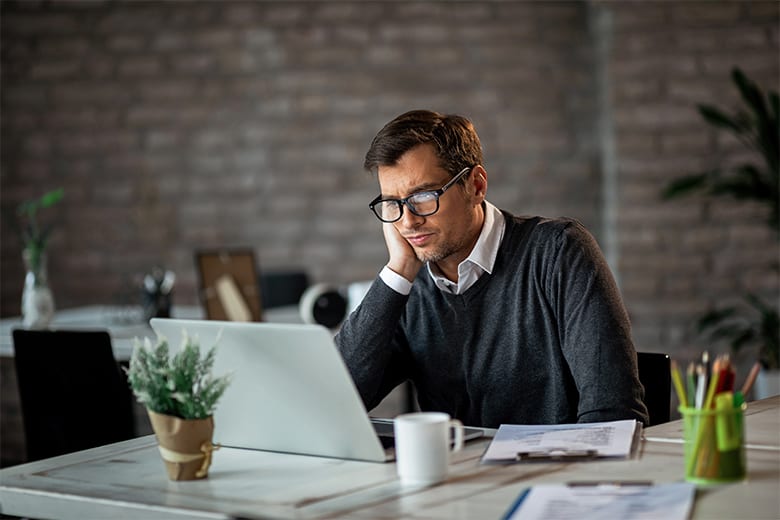 Man looking confused at laptop