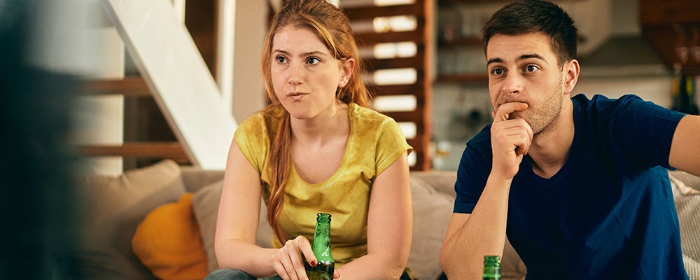 A couple watching sports on broadcast television
