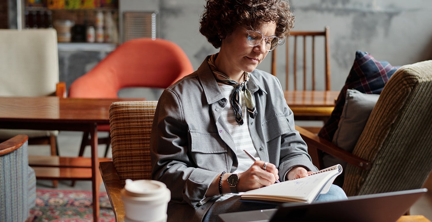 Woman writing at a local coffee shop